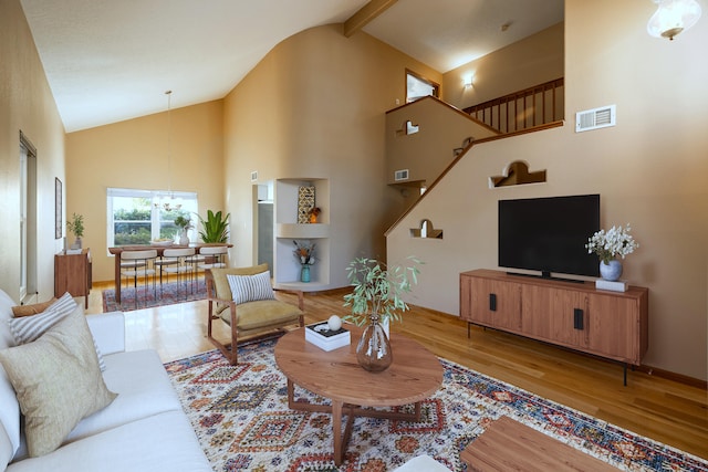 living room with light hardwood / wood-style flooring, beam ceiling, and high vaulted ceiling