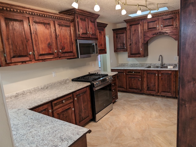 kitchen with light stone counters, sink, a textured ceiling, decorative light fixtures, and stainless steel appliances