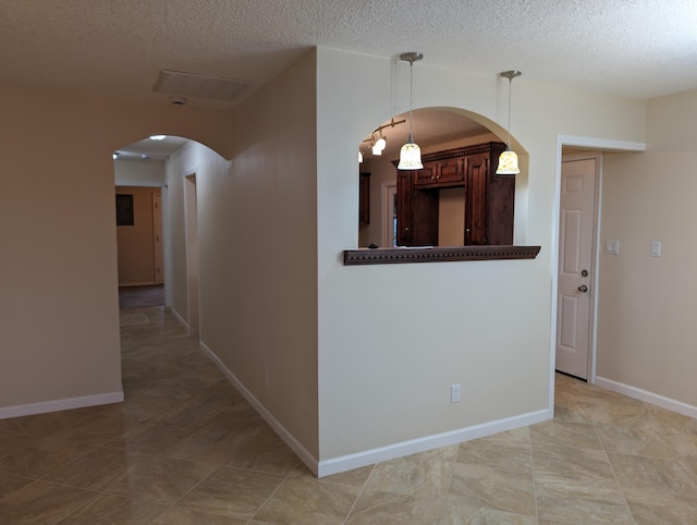 interior space with a textured ceiling and light tile patterned floors