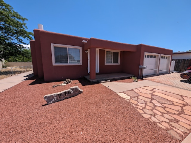 pueblo-style home featuring a garage