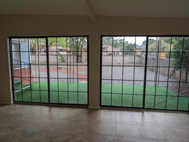 entryway with tile patterned flooring and beam ceiling