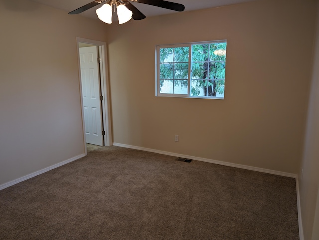 carpeted spare room featuring ceiling fan