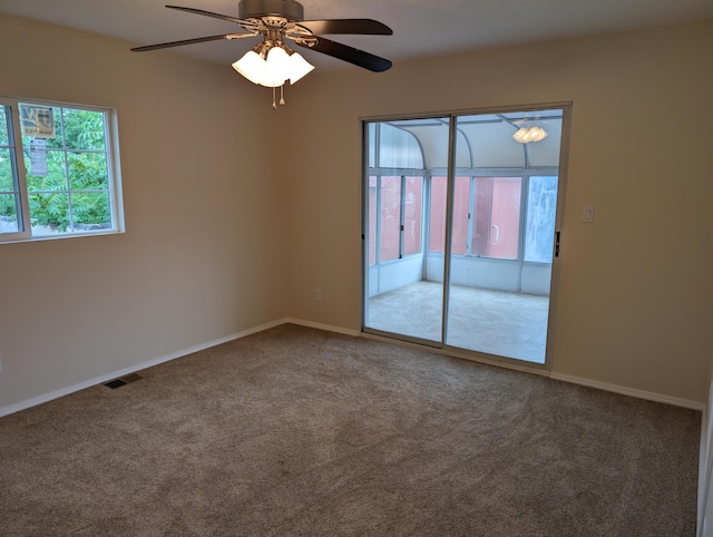 spare room with carpet flooring, ceiling fan, and a wealth of natural light