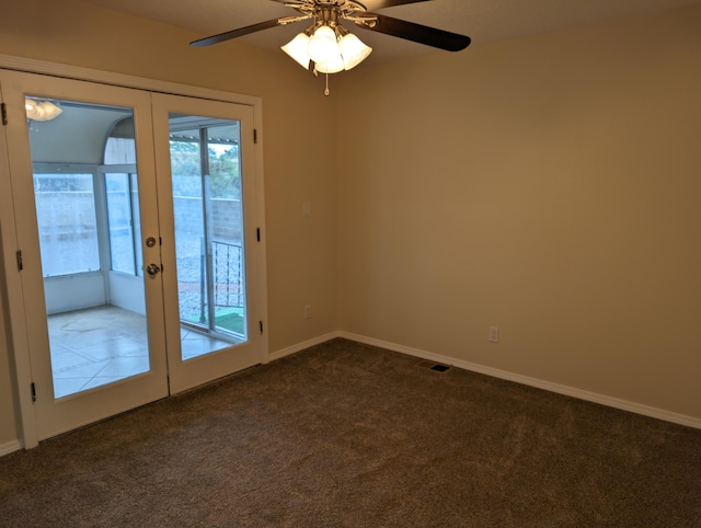 carpeted spare room featuring ceiling fan and french doors