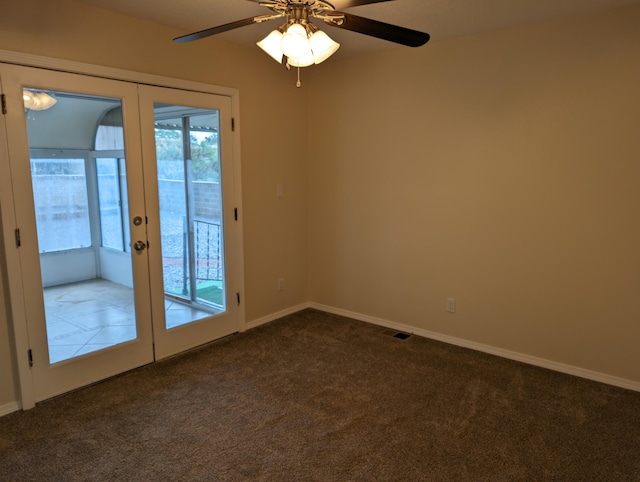 spare room with baseboards, french doors, a ceiling fan, visible vents, and dark carpet