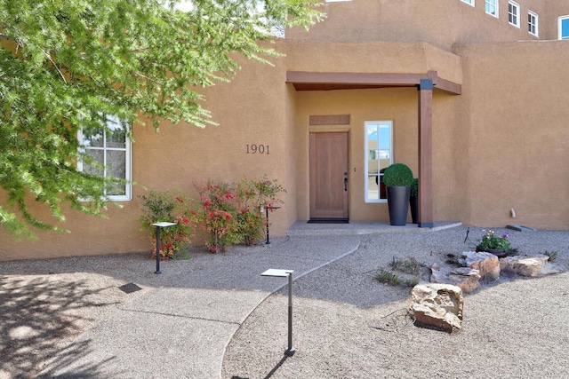 view of exterior entry featuring stucco siding