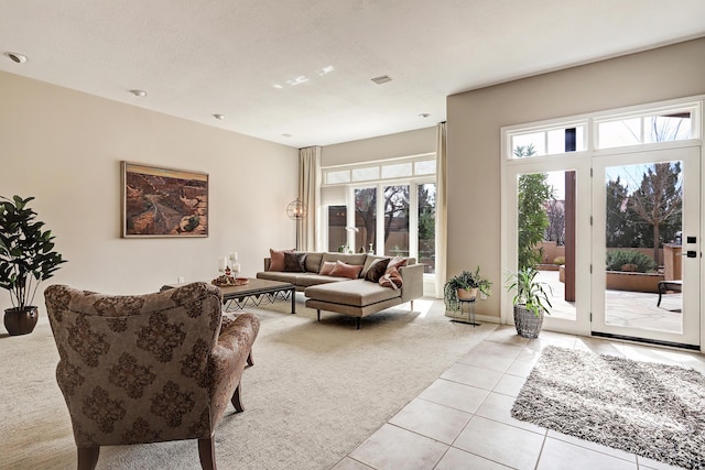 living area with light tile patterned floors, light colored carpet, and visible vents