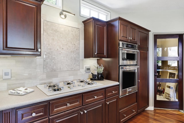 kitchen with a wealth of natural light, decorative backsplash, double oven, and white gas stovetop