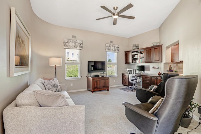 living area featuring a ceiling fan, light colored carpet, and baseboards