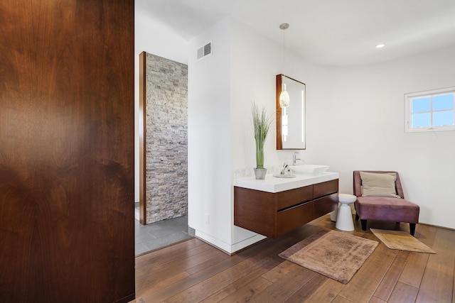 full bath with visible vents, vanity, and hardwood / wood-style floors