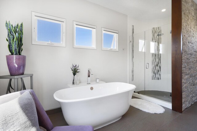 full bathroom with tile patterned flooring, a shower stall, and a freestanding bath