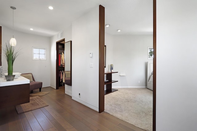 corridor with recessed lighting, visible vents, wood-type flooring, and baseboards