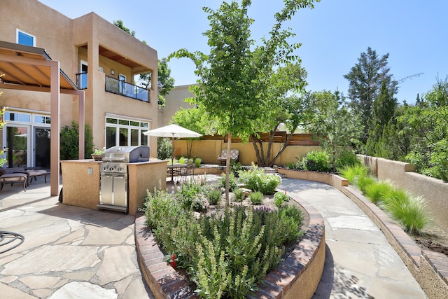 view of patio with area for grilling, exterior kitchen, and fence