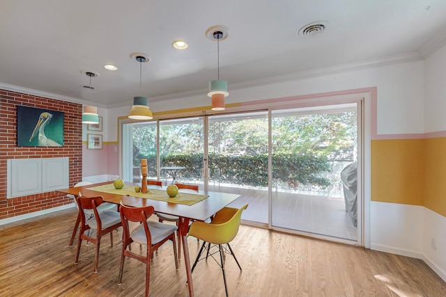 dining space with light wood-type flooring and crown molding