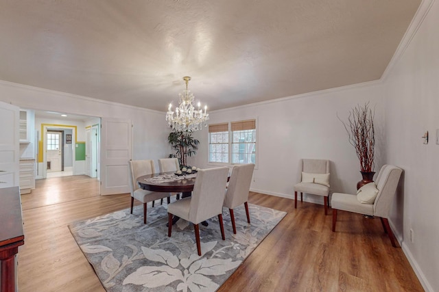 dining room featuring crown molding, light hardwood / wood-style flooring, and a notable chandelier