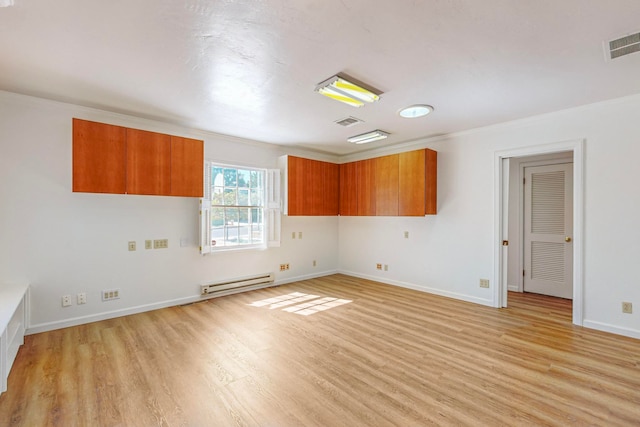 spare room featuring light hardwood / wood-style flooring and a baseboard heating unit