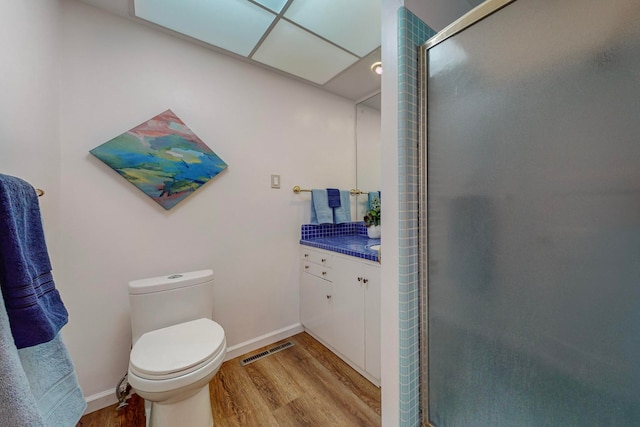 bathroom with wood-type flooring, vanity, toilet, and an enclosed shower