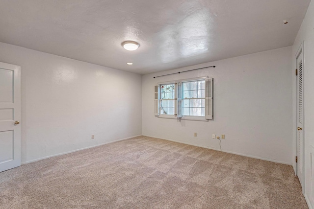 unfurnished bedroom featuring light carpet and a textured ceiling