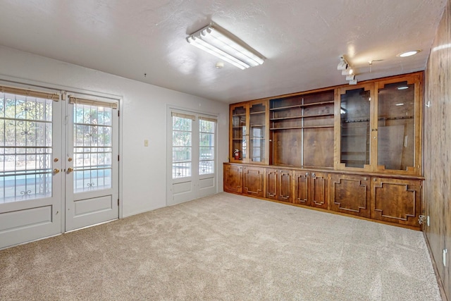 unfurnished room with a textured ceiling and light colored carpet