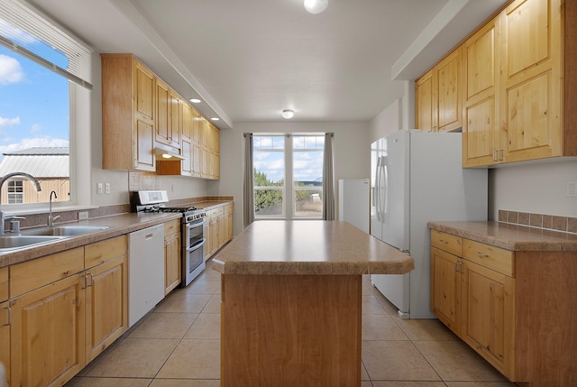 kitchen with white appliances, light brown cabinetry, sink, a kitchen island, and light tile patterned floors