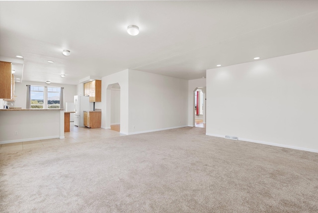 unfurnished living room with light carpet