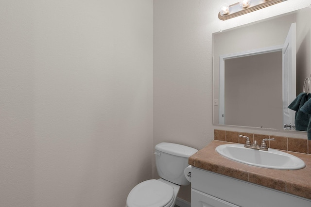 bathroom featuring backsplash, vanity, and toilet