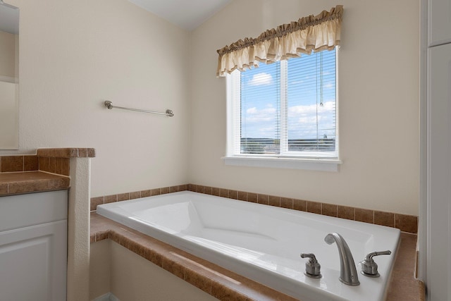 bathroom featuring vanity and a relaxing tiled tub