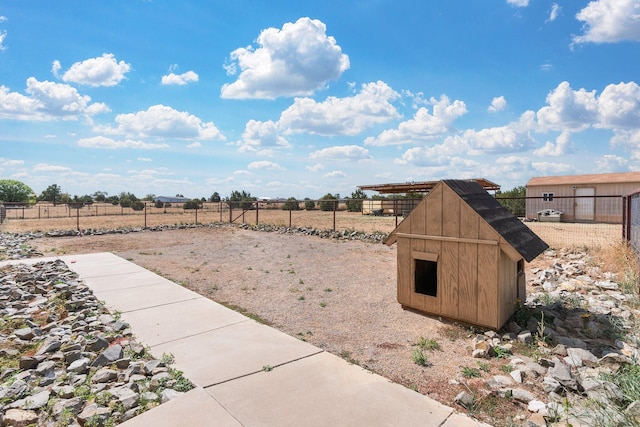 view of yard with a shed and a rural view