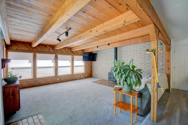 sitting room with beamed ceiling, wood ceiling, brick wall, wooden walls, and hardwood / wood-style floors