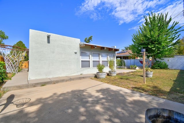 rear view of property with a lawn and a patio