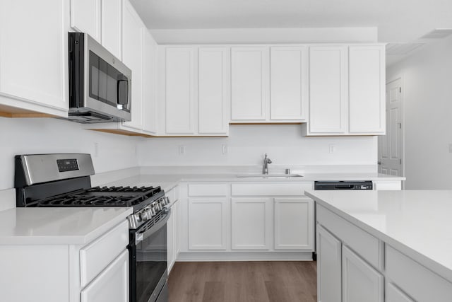 kitchen featuring a sink, light countertops, white cabinets, appliances with stainless steel finishes, and light wood-type flooring