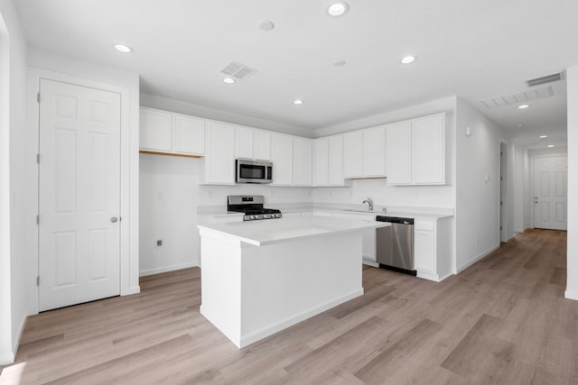 kitchen with white cabinets, visible vents, appliances with stainless steel finishes, and a kitchen island