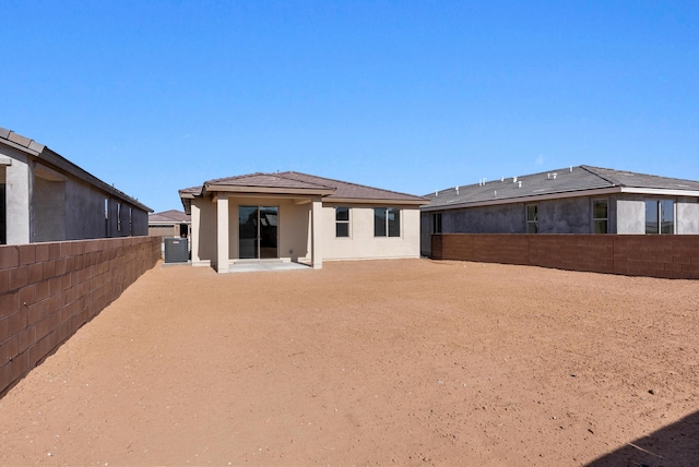 back of property with stucco siding, cooling unit, and a fenced backyard