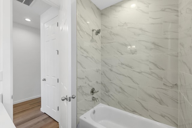 bathroom with visible vents, baseboards, shower / tub combination, recessed lighting, and wood finished floors