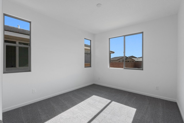 carpeted spare room featuring baseboards