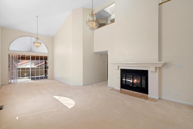 unfurnished living room featuring a notable chandelier, high vaulted ceiling, and carpet flooring