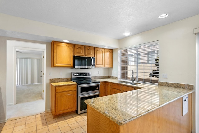 kitchen featuring light colored carpet, kitchen peninsula, sink, and stainless steel appliances