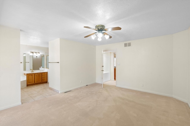 interior space with ceiling fan, light colored carpet, a textured ceiling, and sink