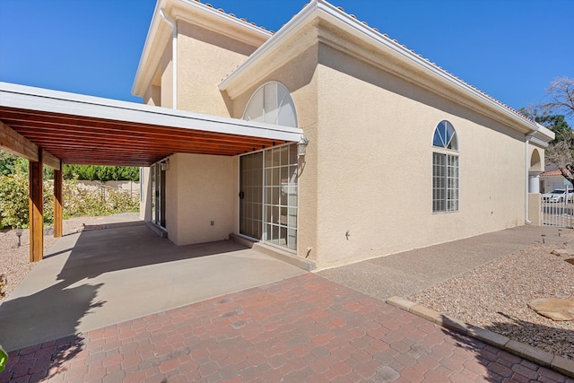 back of house featuring a patio area and a carport