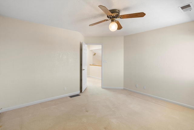 empty room featuring ceiling fan and light colored carpet