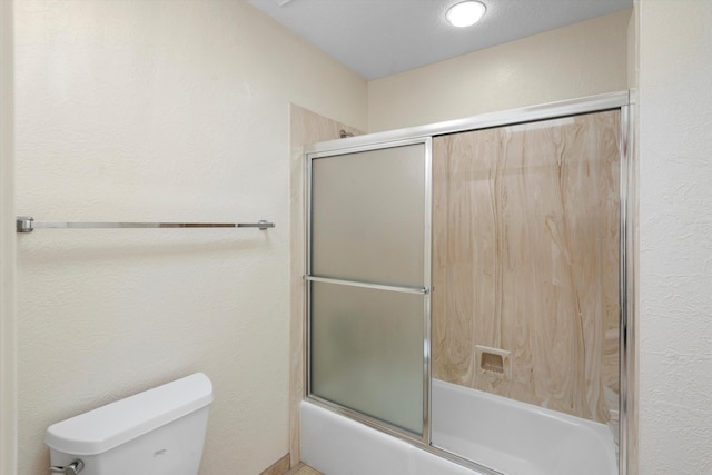 bathroom featuring enclosed tub / shower combo and toilet