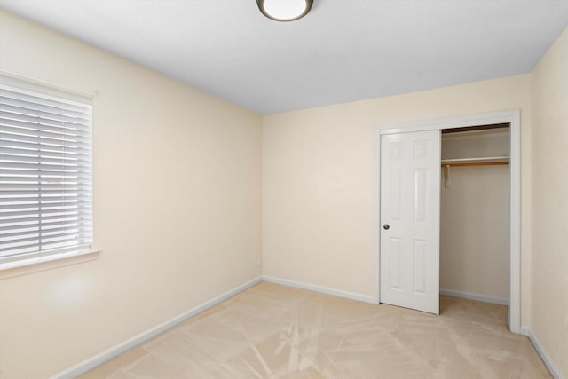 unfurnished bedroom with light carpet and a closet