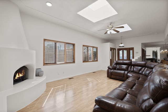 2616 Don Pedro NW, Albuquerque, NM 87104 - living area featuring baseboards, light wood-type flooring, a skylight, and a fireplace