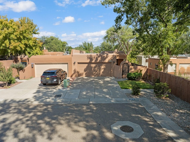 2616 Don Pedro NW, Albuquerque, NM 87104 - view of front of house featuring driveway, a gate, stucco siding, a fenced front yard, and a garage