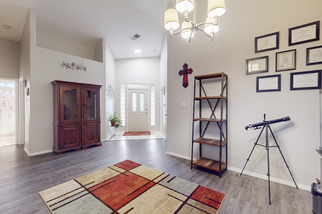 entrance foyer with a high ceiling, an inviting chandelier, and dark wood-type flooring