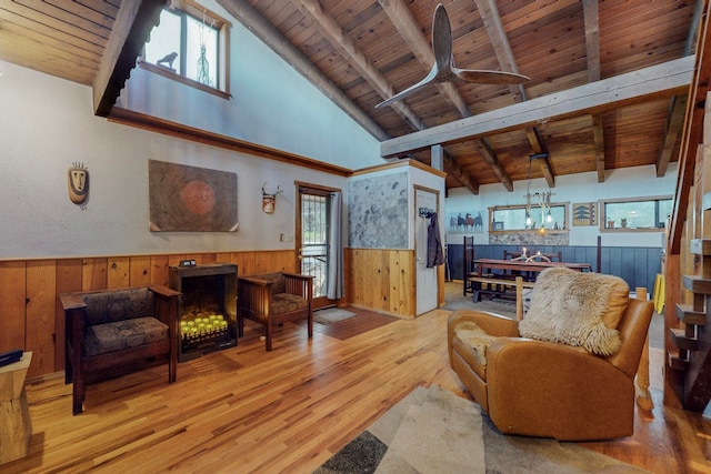 living room featuring light hardwood / wood-style floors, a healthy amount of sunlight, wood ceiling, and wooden walls