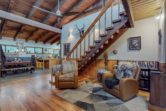 living room with wood-type flooring, vaulted ceiling with beams, wood walls, and wooden ceiling