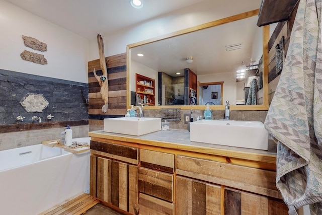 bathroom with backsplash, a washtub, and vanity