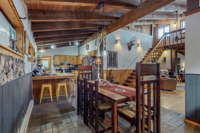 dining space featuring high vaulted ceiling, wood walls, beamed ceiling, and wooden ceiling