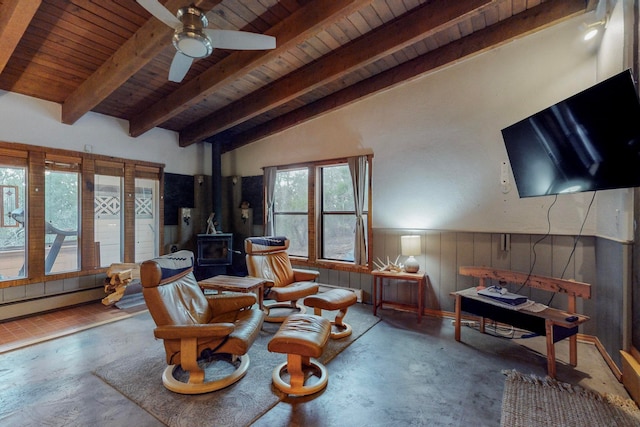 sitting room with ceiling fan, lofted ceiling with beams, a wood stove, and wooden ceiling